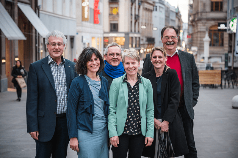 Eine Gruppe von Menschen posiert für ein Foto in einer Stadt.